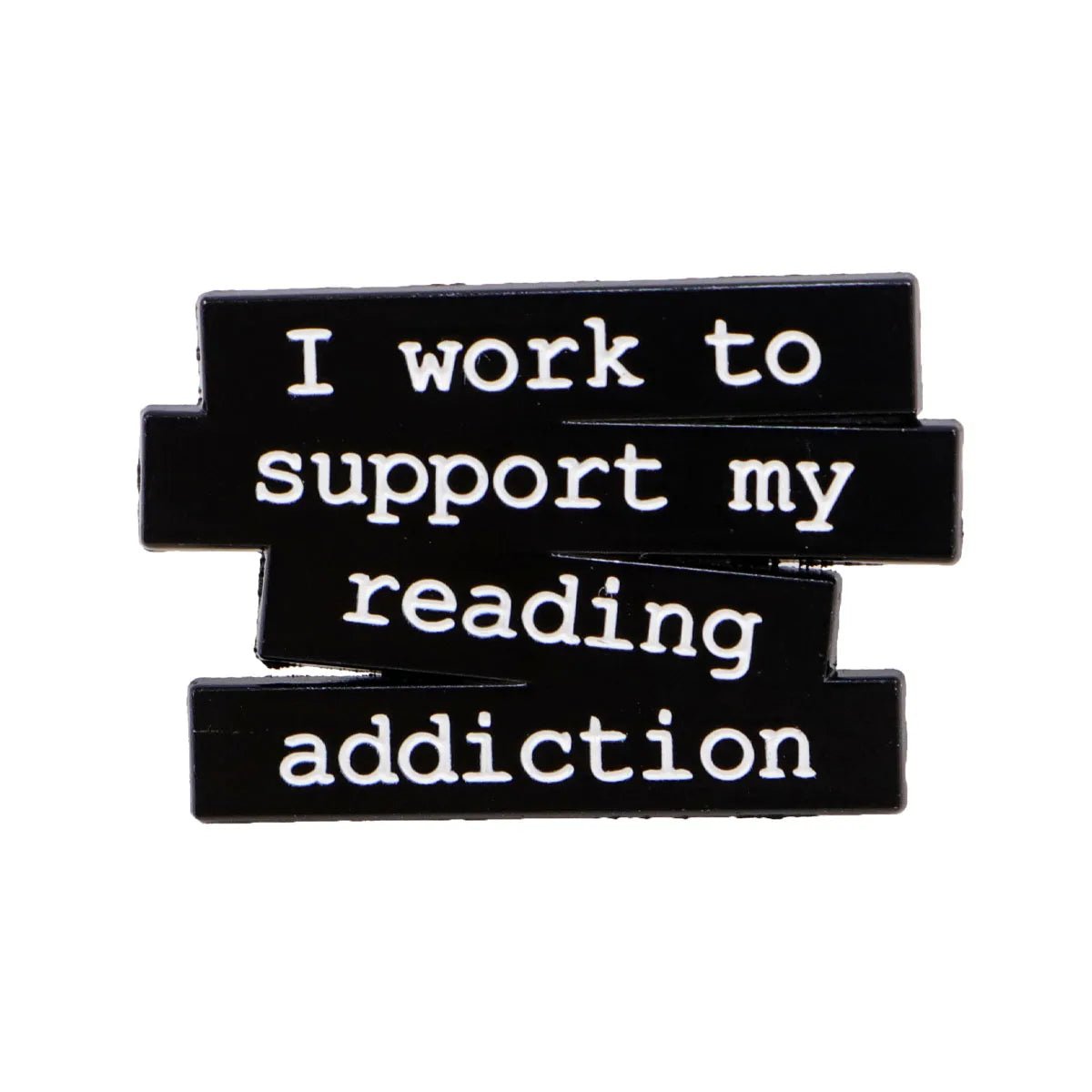 A black pin with white text reads “I work to support my reading addiction” and includes a small red enamel heart for a charming touch.