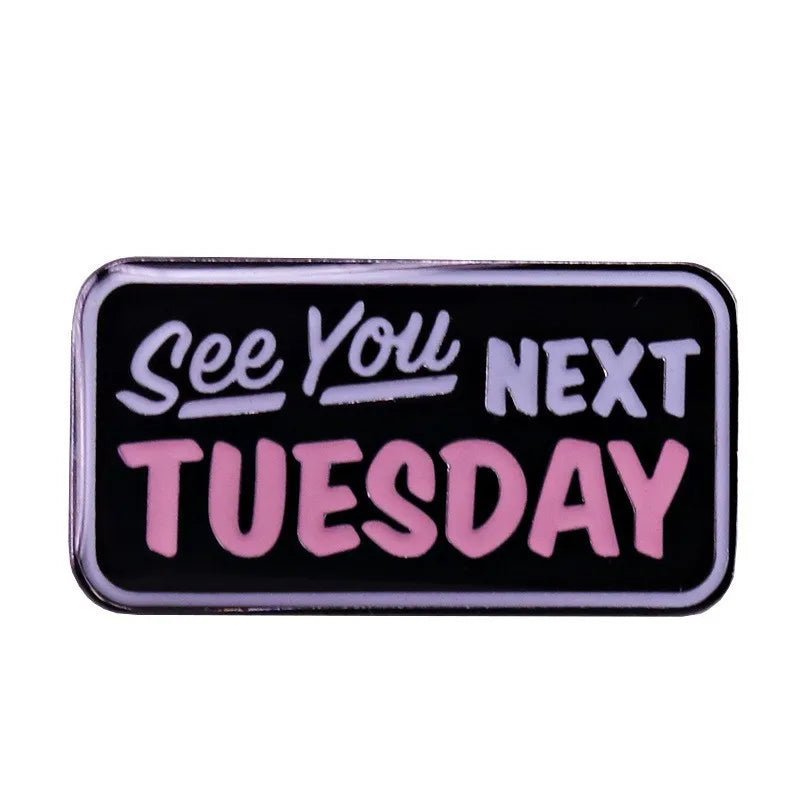 Rectangular badge has a black background with white and pink “See You Next Tuesday” text in mixed fonts—a cheeky nod to the C U N T acronym.
