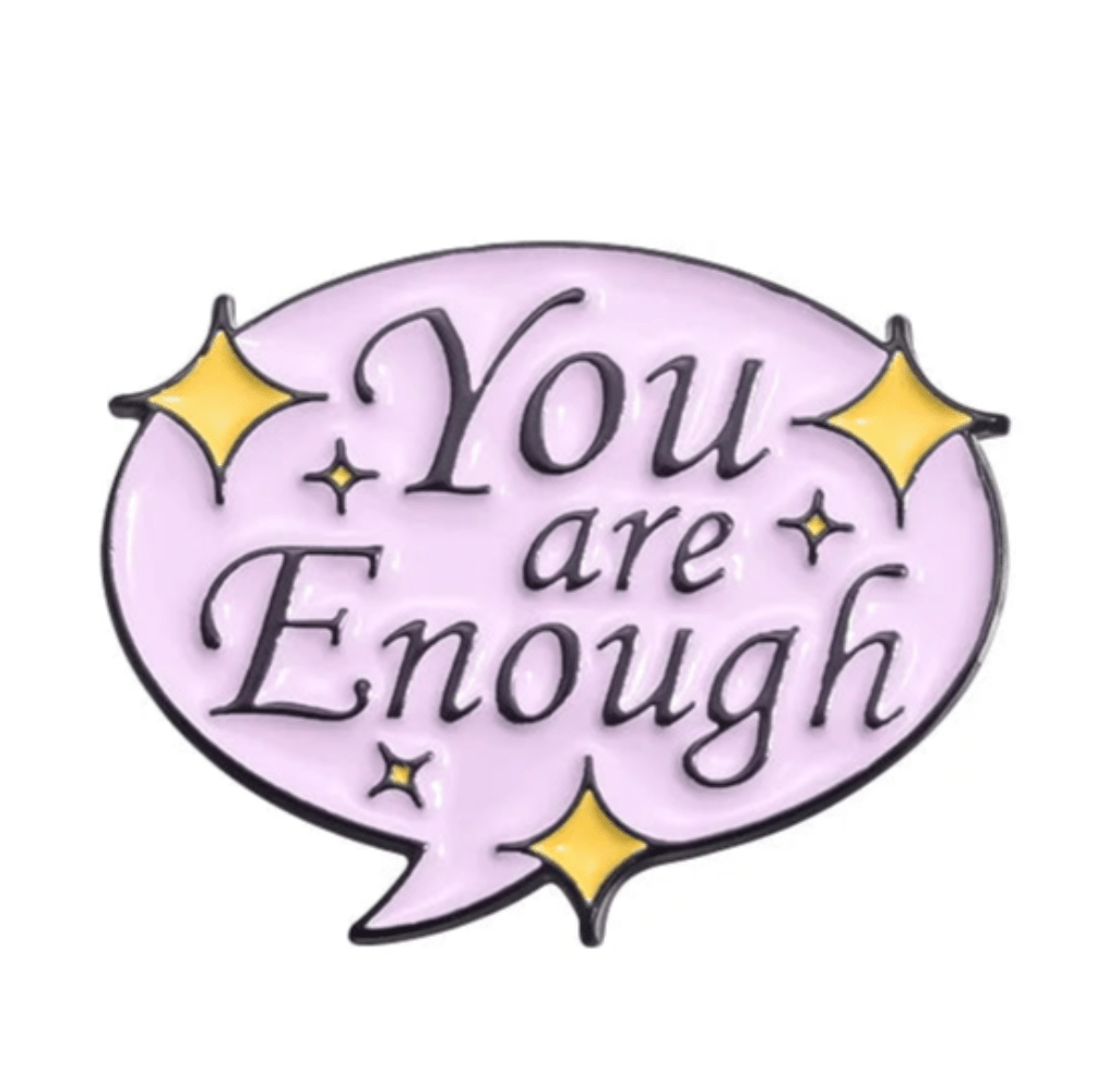 The Kiss Me Later pastel purple speech bubble enamel pin features You are Enough in black, accented with four yellow star sparkles. This limited edition motivational accessory is perfect for brightening your day.