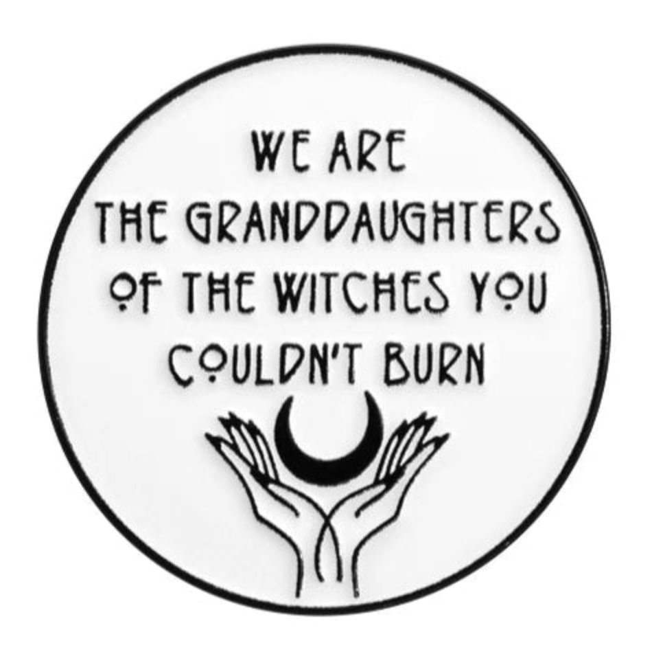 A circular Kiss Me Later badge features “We are the granddaughters of the witches you couldn’t burn” above two hands holding a crescent moon—ideal for empowered women and fans of feminist enamel pins.