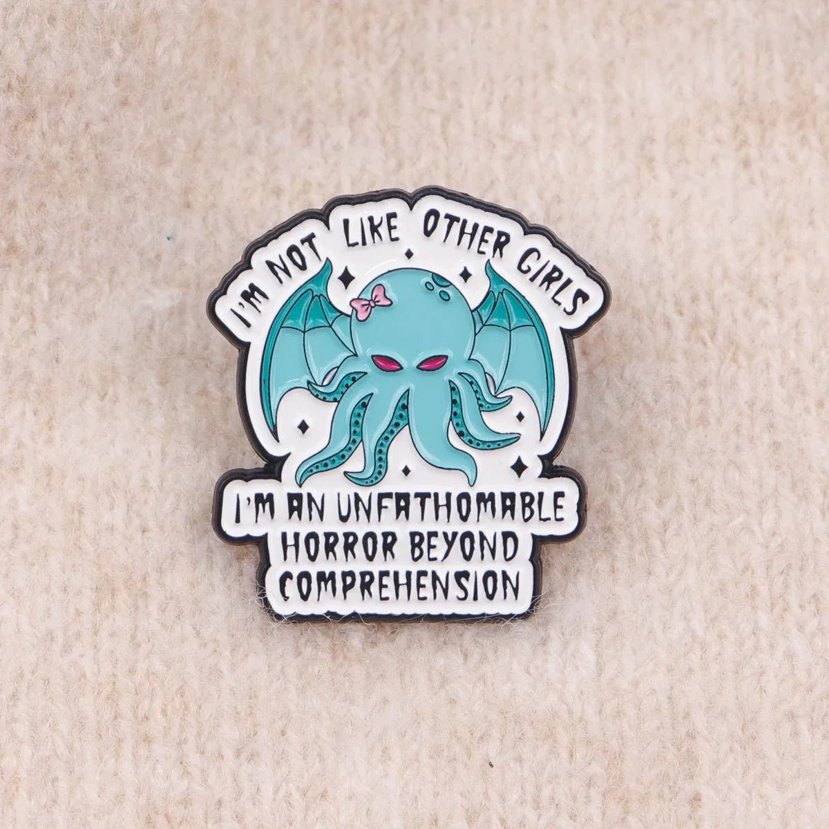 Show off your quirky style with this Gay Skate enamel badge featuring a teal cartoon octopus with bat wings and a pink bow. Text reads, I’m not like other girls—I’m an unfathomable horror beyond comprehension.