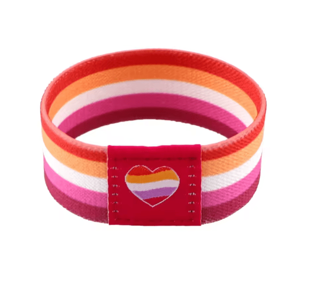 The Gay Skate fabric wristband has horizontal stripes in orange, pink, red, and white with a cute heart patch—ideal as a colorful pride accessory.