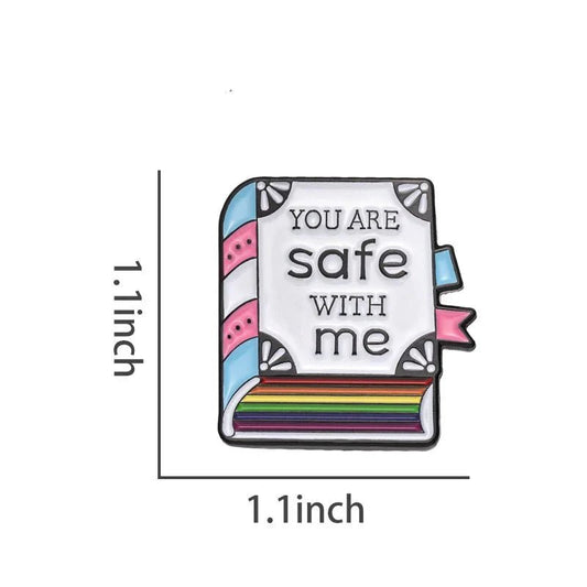 Show your support with the Kiss Me Later enamel pin—a 1.1 square book-shaped accessory featuring rainbow pages, a pastel cover that reads You are safe with me, and a design perfect for celebrating trans pride.