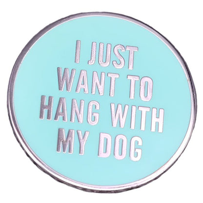 My Cutesy Eras blue enamel pin features silver text that says I JUST WANT TO HANG WITH MY DOG on a light blue background, adding a playful touch for dog lovers.