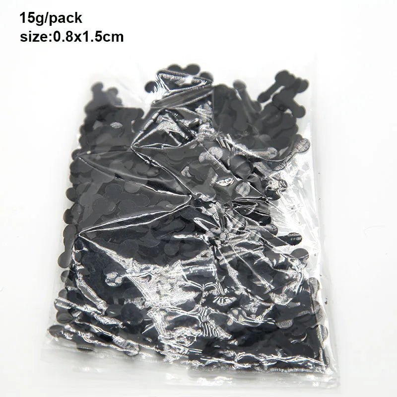 A clear plastic bag from Kiss Me Later contains small black bone-shaped confetti (0.8x1.5cm, 15g/pack). Ideal for themed events or adult parties.