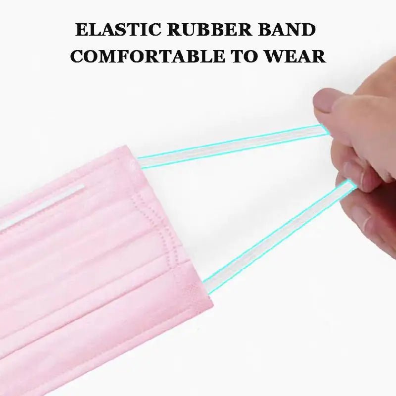 A hand stretches the elastic ear loops of a pink Kiss Me Later disposable medical face mask, showcasing its flexibility. Above the image, text reads: ELASTIC RUBBER BAND COMFORTABLE TO WEAR.