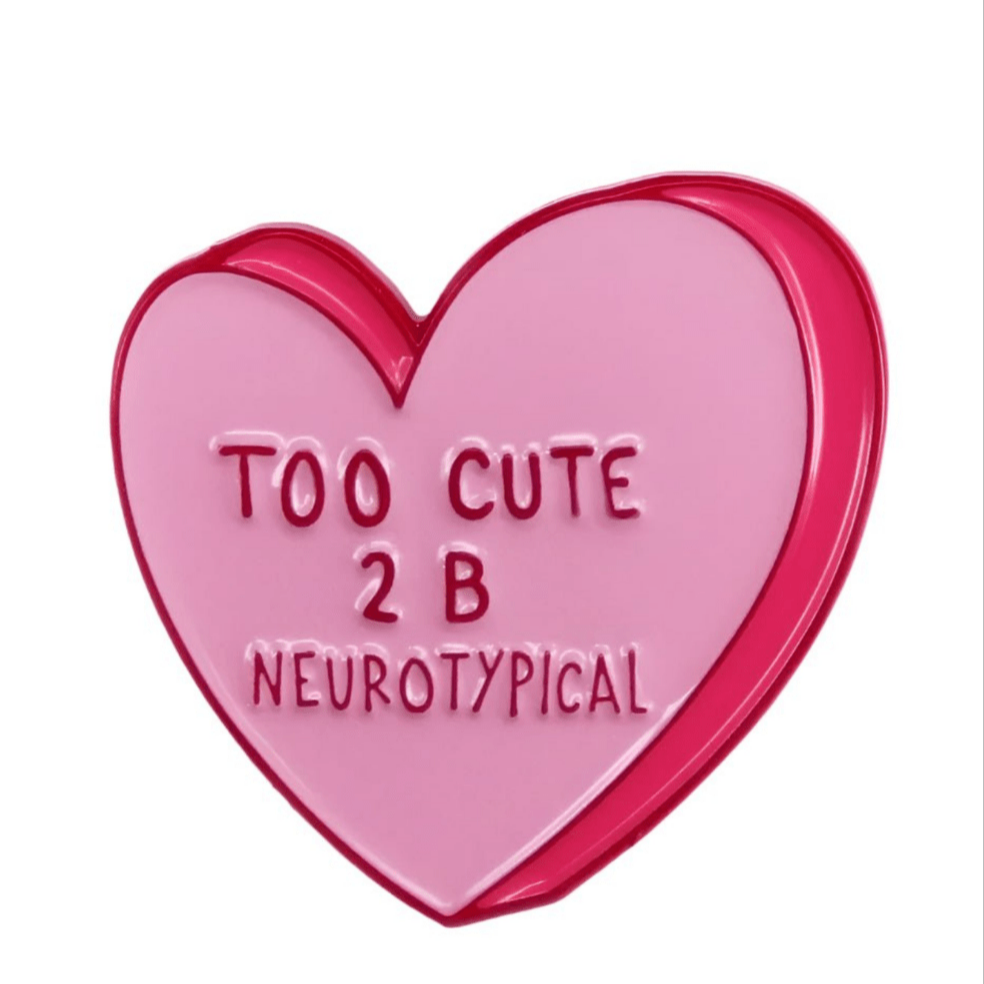 A My Cutesy Era pin shaped like a pink candy heart with a red outline features TOO CUTE 2 B NEUROTYPICAL embossed on the front. This neurodiversity-themed accessory is displayed against a plain white background.