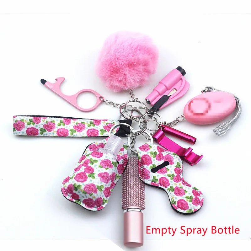 The Kiss Me Later keychain set features pink and floral personal safety accessories: a fluffy pom-pom, whistle, touch tool, pepper spray, flashlight, spray bottle labeled Empty Spray Bottle, and a lip balm holder—perfect for outdoor adventures.