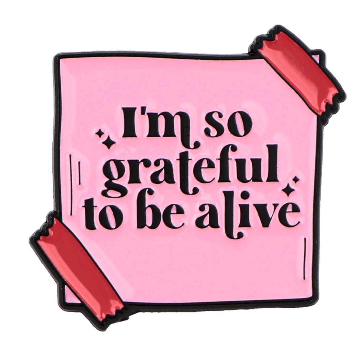 A pink square badge reads Im so grateful to be alive in bold black letters, held by shiny red tape—an uplifting affirmation for mental health and daily self-empowerment.