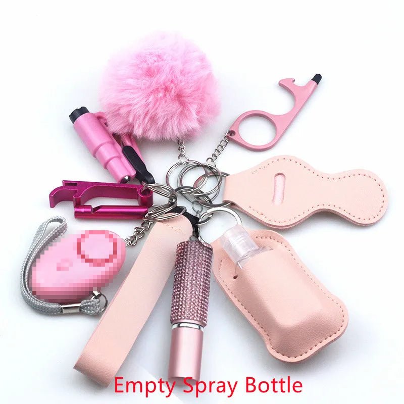 The Kiss Me Later pink keychain set is perfect for outdoor adventures and includes a fluffy pom-pom, safety alarm, pepper spray, no-touch tool, chapstick holder, wrist strap, and an empty spray bottle with red text.