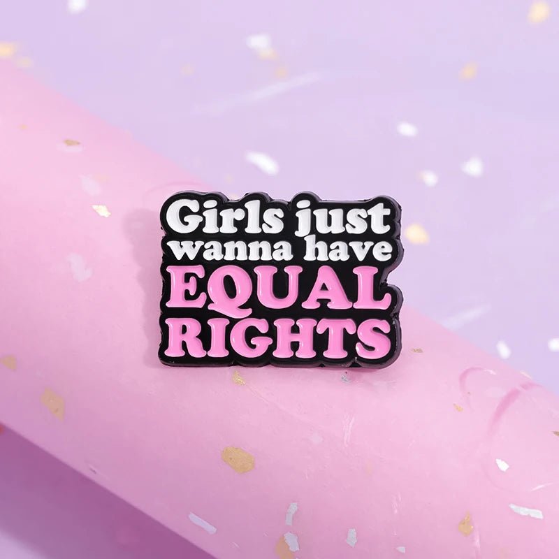 Feminist Pin features Girls just wanna have EQUAL RIGHTS in bold black, white, and pink on a pink and lavender background—ideal for expressing your style while supporting equality.
