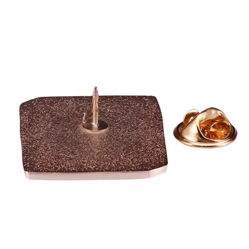 A square metallic pin badge from Kiss Me Later, featuring a textured surface and pointed back, is shown with its gold-colored butterfly clutch—an ideal library-themed gift for book lovers.