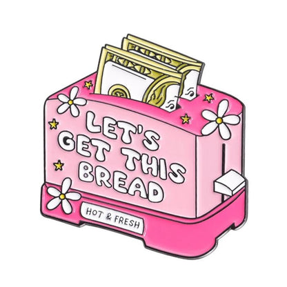 Pink toaster enamel pin says LETS GET THIS BREAD, with dollar bills as toast, white flowers, a HOT & FRESH base label, and playful Red Lips Cash Roll vibes.
