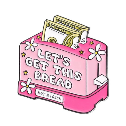 Pink toaster enamel pin says LETS GET THIS BREAD, with dollar bills as toast, white flowers, a HOT & FRESH base label, and playful Red Lips Cash Roll vibes.
