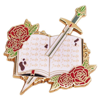 Enamel pin for Romance Readers features a gold-edged open book with Jude on its pages, red roses, and a diagonal sword—ideal for book lover badge collections.