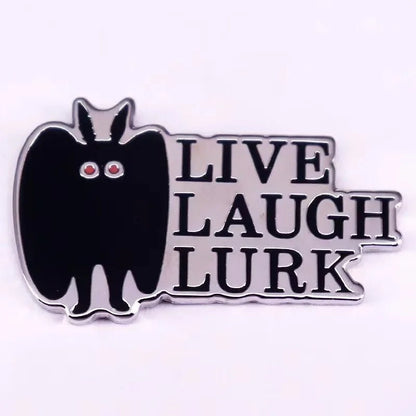 Add a spooky statement to your look with a pin featuring a black bat with red eyes beside LIVE LAUGH LURK in bold, silver—perfect for pairing with your favorite Gothic spider pin.