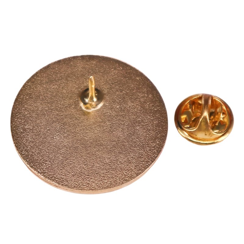 Close-up of a Kiss Me Later round enamel pin with a gold-colored, textured back and a separate butterfly clutch fastener beside it on a white background.