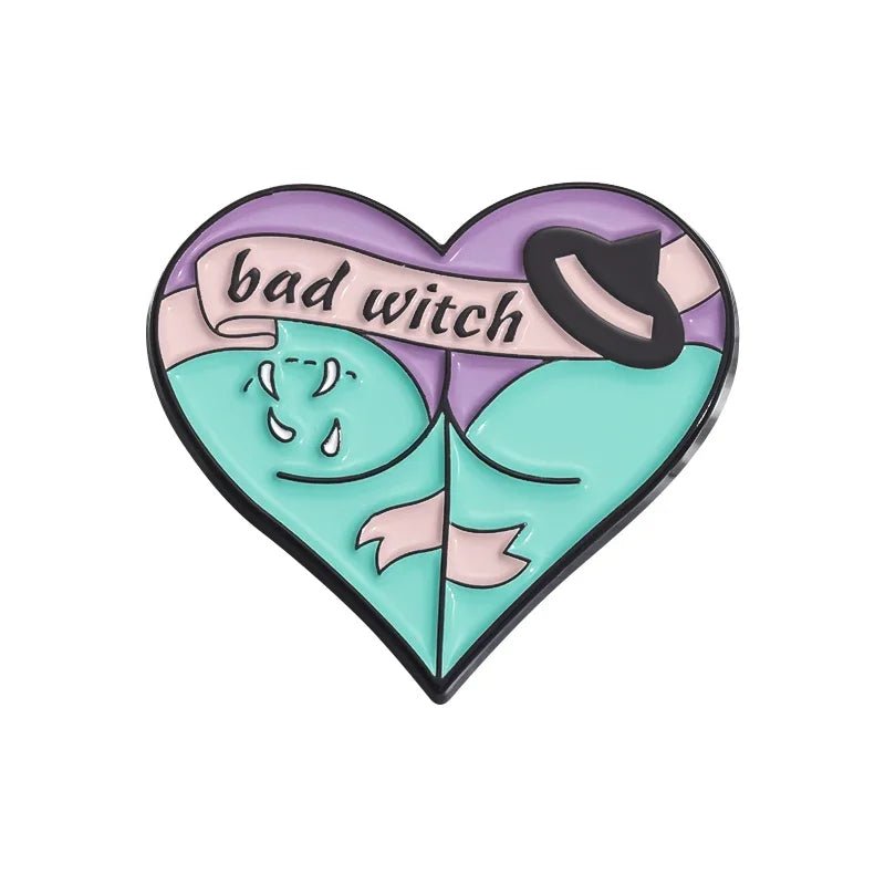 Enamel pin features a heart shape in pastel hues, bad witch text, a hat, stylized hills, and gothic touches—all outlined in black.