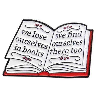 An illustration by My Cutesy Era features an open book with the quote "we lose ourselves in books, we find ourselves there too" across its pages. The red cover and decorative details make it a great gift for book lovers or bookworm accessories.