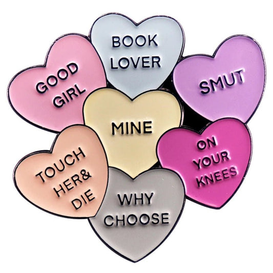 Seven pastel candy hearts with bold phrases like BOOK LOVER and SMUT form a circular cluster—this vibrant pin by My Cutesy Era is the perfect spicy accessory for any Book Lover enamel pin collection.