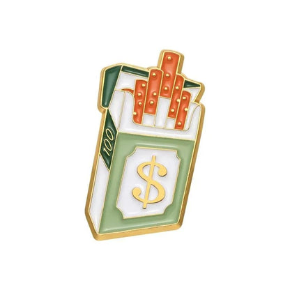 A bold accessory - a gold-edged enamel pin shaped like a cigarette pack with a large dollar sign, filled with orange gold bar-like cigarettes.