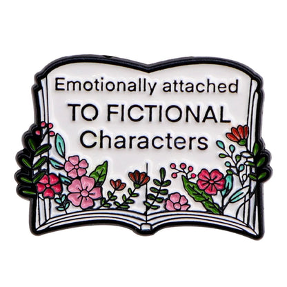 Enamel pin features an open book with vibrant flowers and Emotionally attached TO FICTIONAL Characters on its pages—a perfect accessory for any booktrovert who loves the magic of stories.