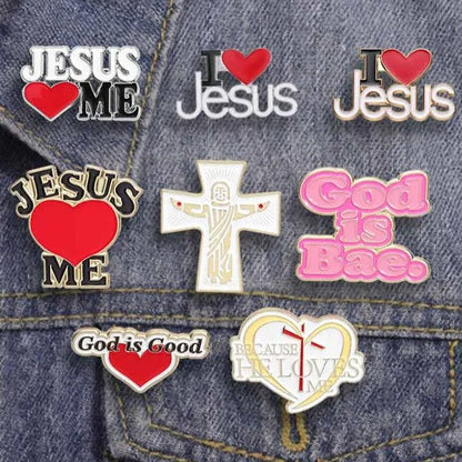 A close-up of a My Cutesy Era denim jacket shows eight adorable enamel pins with Christian messages, hearts, and crosses. Phrases include “Jesus ❤️ Me,” a pink “God Is Bae” pin, “God is Good,” and “Because He Loves Me.”.