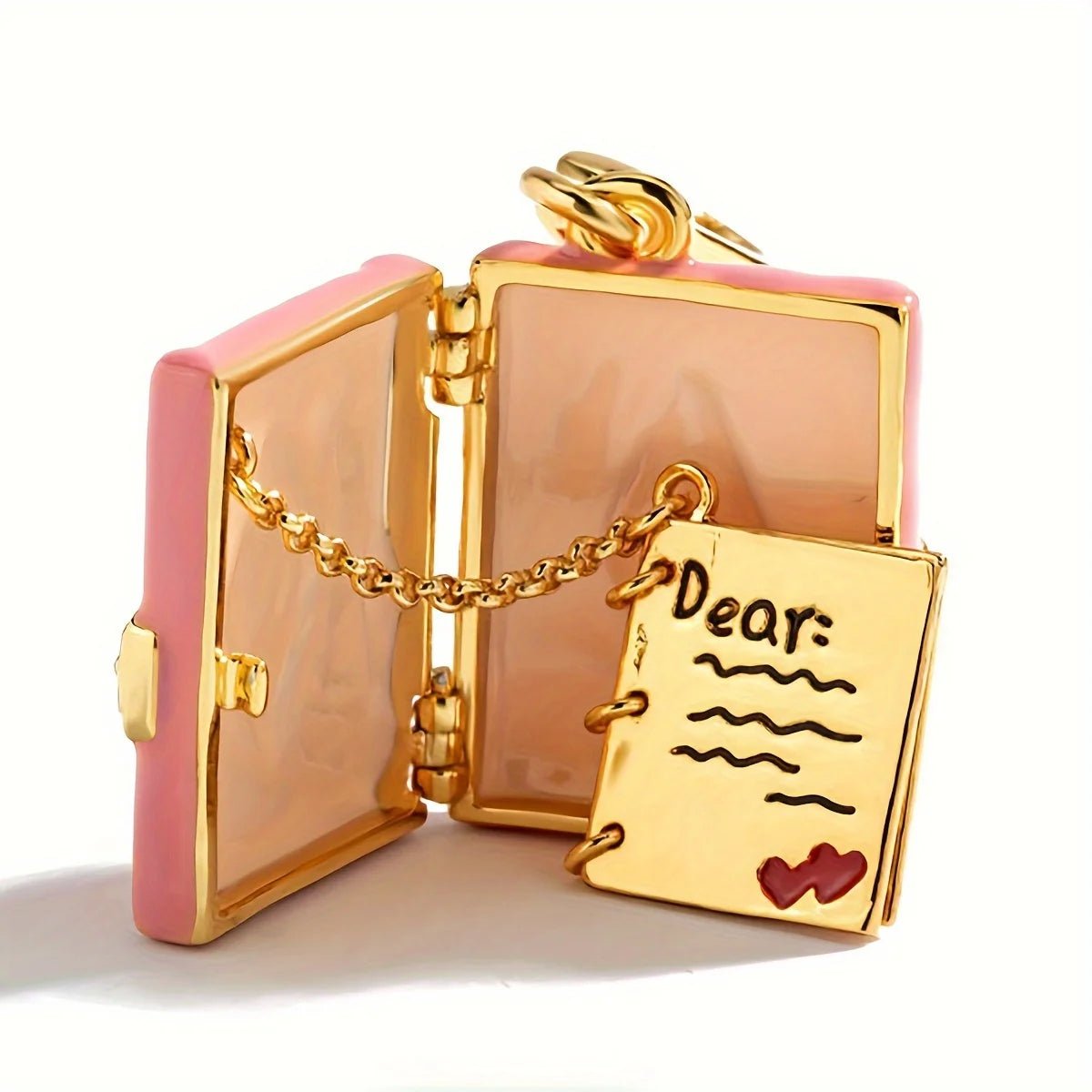 Gold pink enamel locket pendant opens like a book to reveal a tiny gold notebook with “Dear:” and a red heart, linked by a small chain—a charming love letter keepsake for your cherished messages.