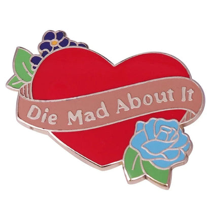 A red heart floral pin from My Cutesy Era, featuring a Die Mad About It ribbon, purple and blue flowers, and green leaves.