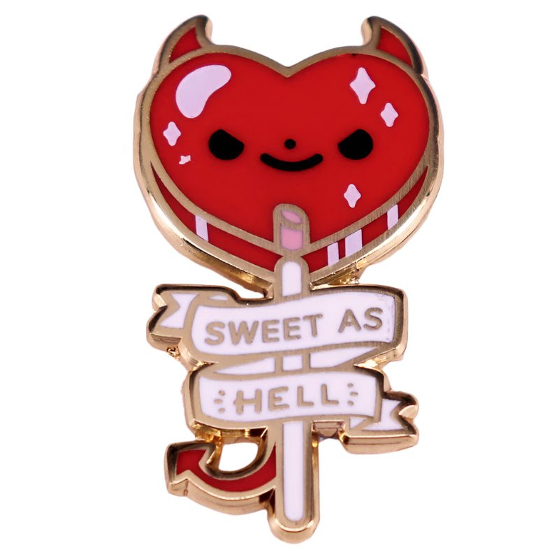 The Kiss Me Later red heart-shaped devil enamel pin features gold outlines, horns, a smiling face, a cute devil tail, and a SWEET AS HELL banner—perfect for adding playful mischief to any outfit.