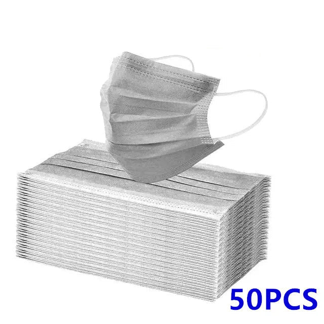 A stack of 50 Kiss Me Later disposable medical face masks with ear loops is shown, with one triple layer mask above the pile. Blue text in the corner reads 50PCS.