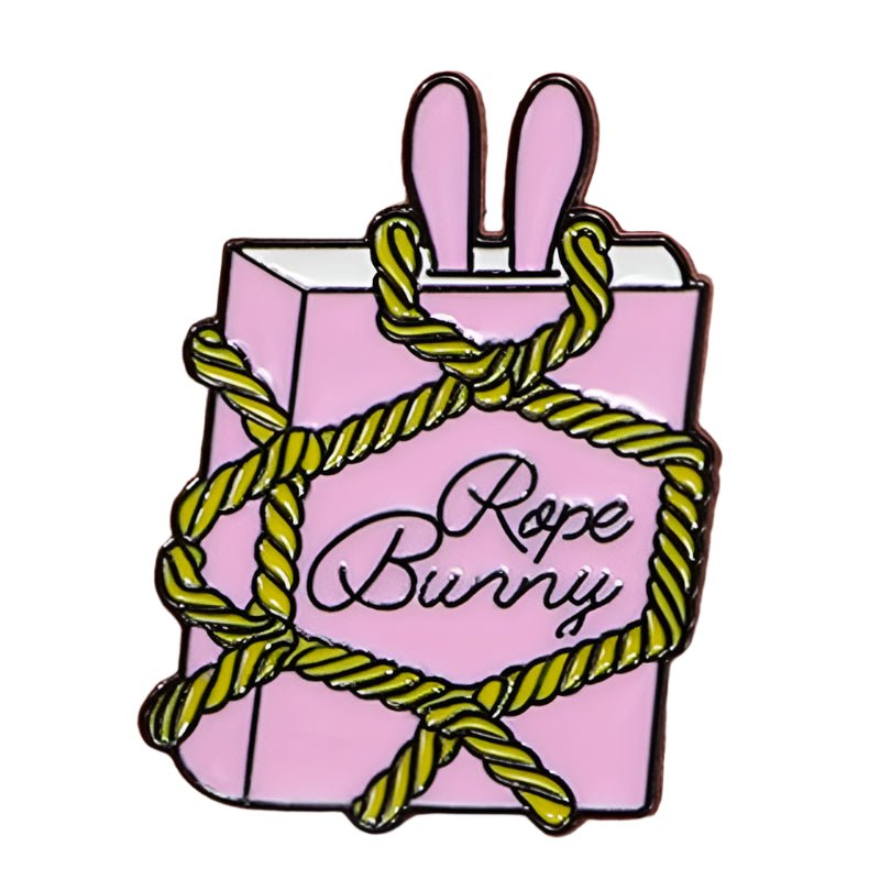 The My Cutesy Era Rope Bunny enamel pin features a pink rectangle with bunny ears wrapped in yellow rope and cursive text on the front—a charming addition to any collection.