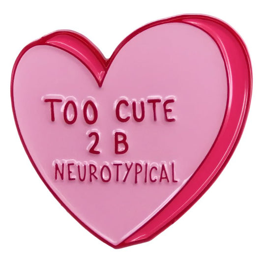 Pink candy love heart pin features red edges and embossed text, “TOO CUTE 2 B NEUROTYPICAL”—a playful accessory celebrating neurodiversity and embracing uniqueness.