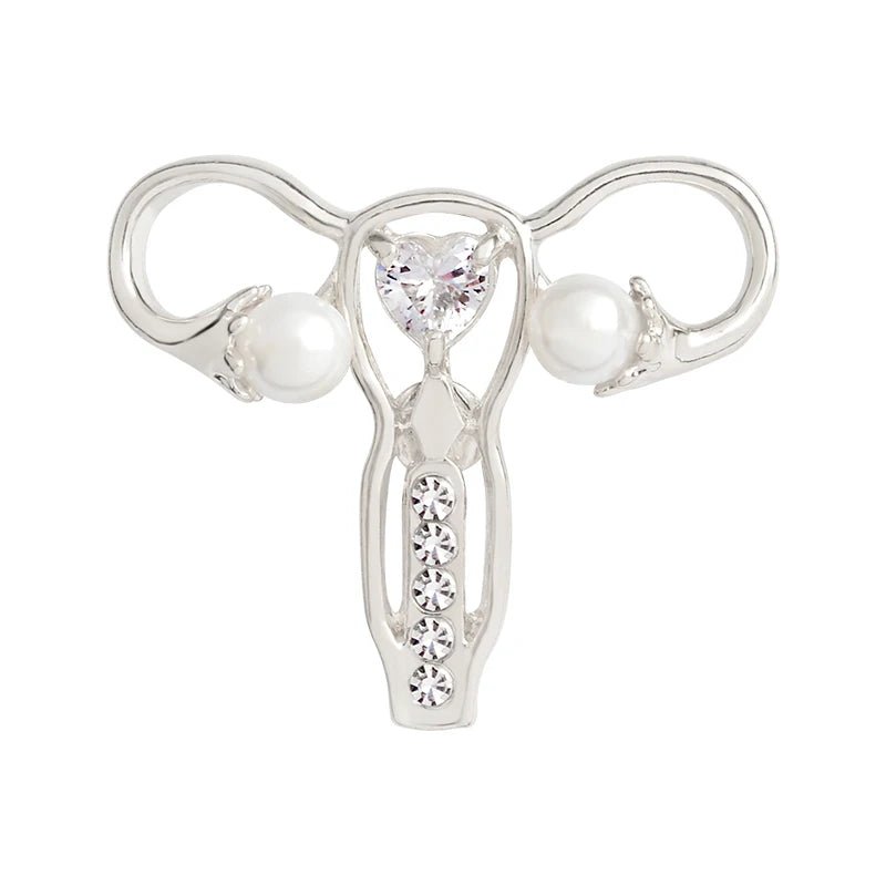 Silver uterus ovary pin features a heart-shaped gem at the center, pearl-like beads on each side, and a row of small gems—making it a perfect feminist gift or stylish medical symbol accessory.
