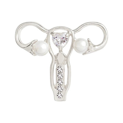 Silver uterus ovary pin features a heart-shaped gem at the center, pearl-like beads on each side, and a row of small gems—making it a perfect feminist gift or stylish medical symbol accessory.