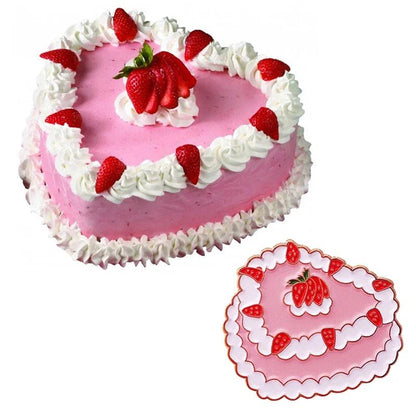 A heart-shaped pink cake by My Cutesy Era, topped with white frosting and a central strawberry cluster, sits beside a matching heart-shaped board with a vintage cake pin accent and playful strawberry pattern.