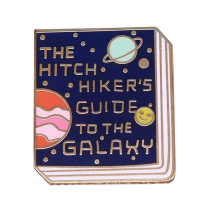 This enamel pin features a book cover of “The Hitchhiker’s Guide to the Galaxy” adorned with cartoon planets, a moon, and a smiling yellow face—an ideal accessory for any book lover’s badge collection.