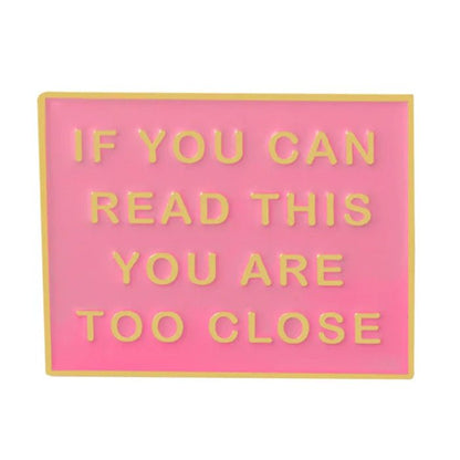 The My Cutesy Era pink rectangular enamel pin features yellow borders and raised yellow text: IF YOU CAN READ THIS YOU ARE TOO CLOSE. This funny lapel pin adds a bold statement to your outfit or bag.