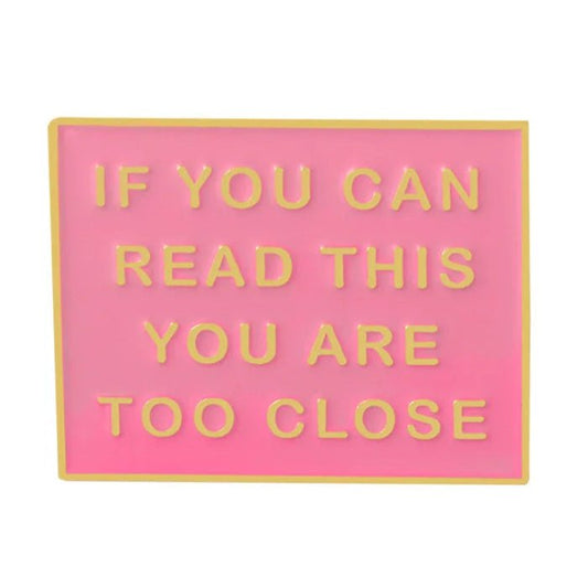 The My Cutesy Era pink rectangular enamel pin features yellow borders and raised yellow text: IF YOU CAN READ THIS YOU ARE TOO CLOSE. This funny lapel pin adds a bold statement to your outfit or bag.