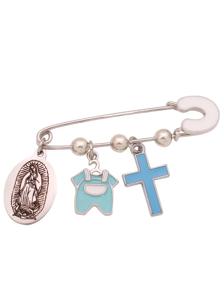 A Kiss Me Later silver Christian baby pin with three charms: an oval Virgin Mary brooch, a small light blue baby onesie, and a blue enamel Cross.