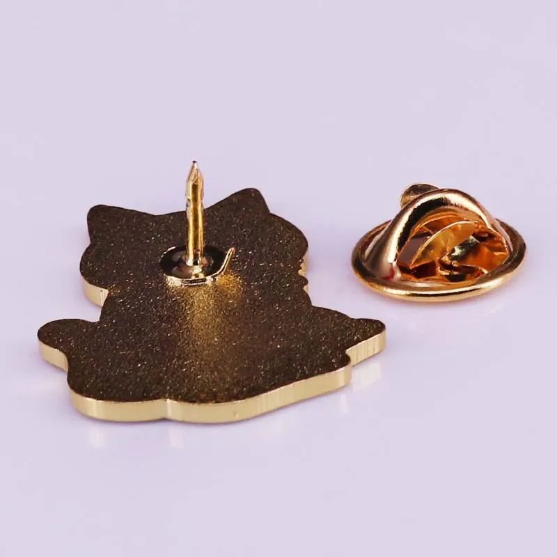 A close-up of the back of a gold-colored metal cat lapel pin, featuring a sharp post and butterfly clutch fastener—ideal for trendy accessory lovers or collectors of unique metal pins.