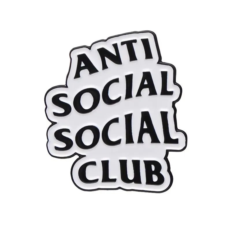 A black and white graphic enamel pin features the phrase ANTI SOCIAL SOCIAL CLUB in bold, overlapping letters with a playful, irregular arrangement.