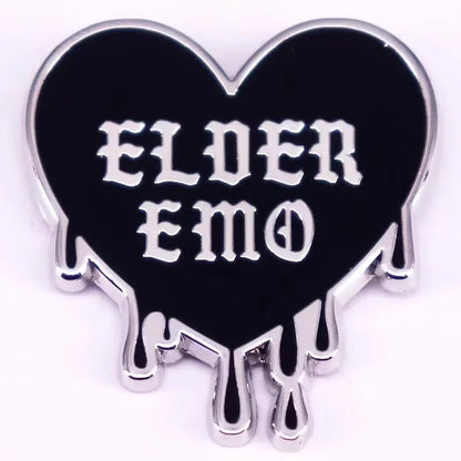 black heart-shaped pin features silver outlines, dripping edges, and bold white Gothic “ELDER EMO” text—perfect for spicing up any Gothic spider pin collection.