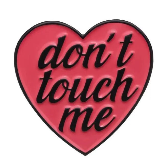 pink heart-shaped enamel pin features bold black dont touch me text on a white background.