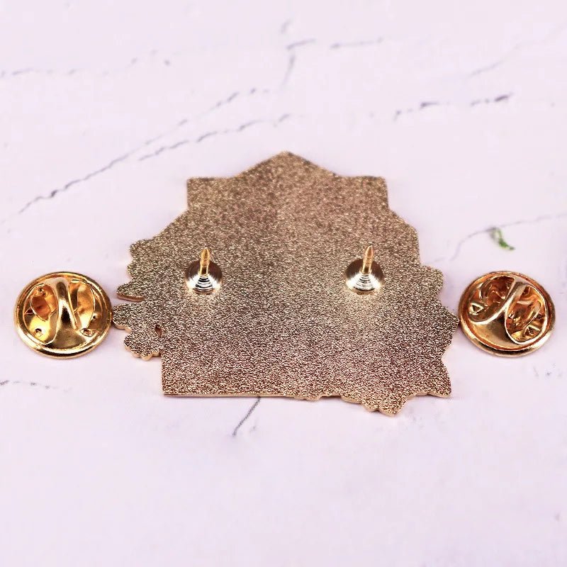 Yellow floral enamel pin features two butterfly clutch pin backs and is displayed from the reverse side on a light marbled background.