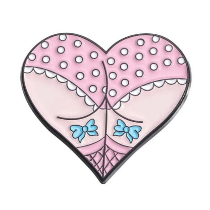Heart-shaped pin mimics a cartoon backside in pink polka-dot undies with white frills, blue bows, and black fishnet details—a quirky accessory for any mermaid at heart.