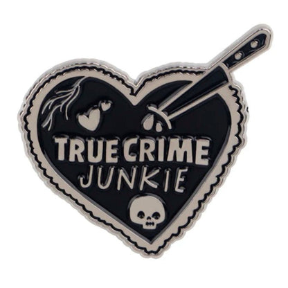 heart-shaped coffin badge says TRUE CRIME JUNKIE and features a skull, dripping knife, and heart details in bold black and silver.