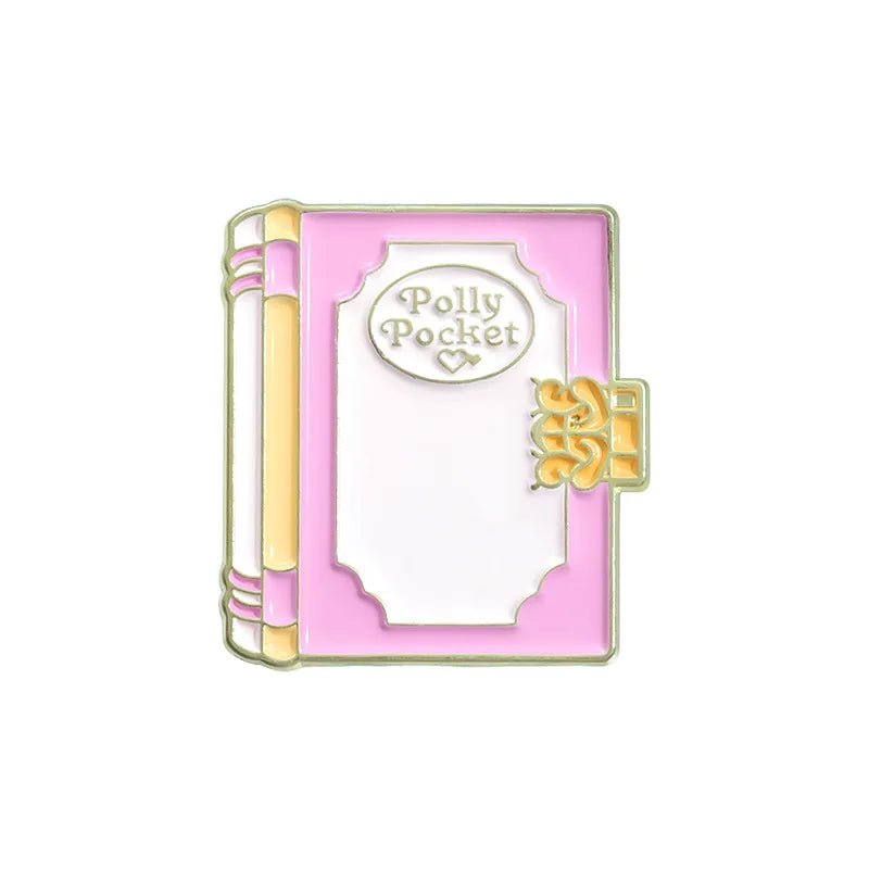 A pastel pink and white enamel pin by My Cutesy Era, shaped like a closed book with “Polly Pocket” on the cover, gold edging, and a heart—perfect as a cute accessory or gift for book lovers.