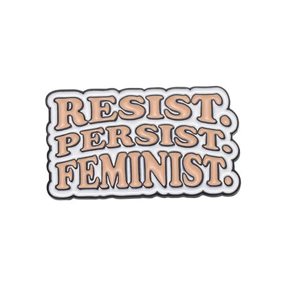 Add to your collection of Feminist Pins with this bold enamel pin featuring peach-colored RESIST. PERSIST. FEMINIST. text outlined in black and white—an empowering statement piece for any outfit!.