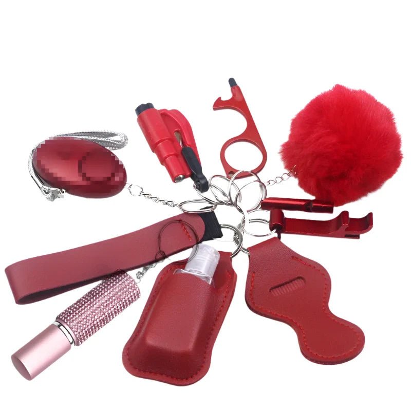 The Kiss Me Later keychain set includes red personal safety accessories: fluffy pom pom, pepper spray, alarm, touch tool, bottle holder, whistle, and a small bottle in a red holder—ideal for outdoor adventures.